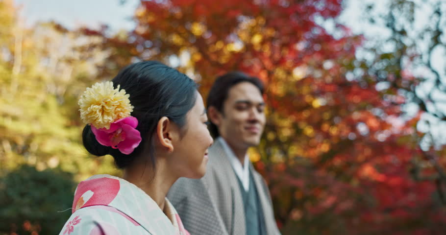 Japanese couple, traditional and walking in garden for sunshine, peace and thinking about life, reflection and date in nature. Travel, people together in park for fresh air and love, care and trust