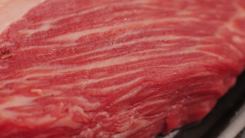 Fresh marbled beef with pepper, salt and rosemary close-up macro. Preparation to cook juicy steak on grill. Premium organic raw wagyu meat