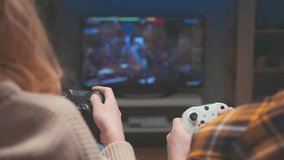 Couple of Gamers Playing Video Game on TV Screen with Console Controllers Closeup. Happy Man and Woman Have Fun at Home with Black and White Player Controls for PC. Two People in Fantasy Fight 4k - Powered by Shutterstock - Get 15% off with code: PIKWIZARD15