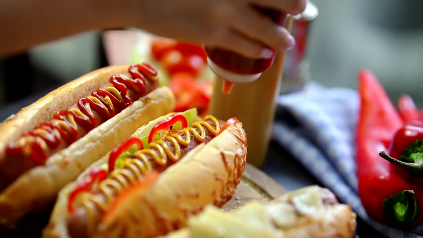 Hot Dog Served Mustard And Ketchup. American Fast Food. Tasty Hot Dog With Grilled Sausage. Appetizing Street Food. Grilled Sausage Hot dog Junk Food. Adding Ketchup And Mustard To Tasty Hot Dog Meat Royalty-Free Stock Footage #3427631209