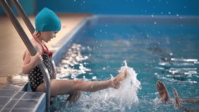 play sports in the pool. little girl in the pool. the child is emotionally happy. slow-motion video. High-quality shooting in 4K format.