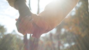 Close-up unrecognizable multiethnic married family couple in love holding hands sunlight caring loving man woman walking in park outdoors romantic date in nature enjoying closeness support tenderness - Powered by Shutterstock - Get 15% off with code: PIKWIZARD15