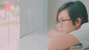 Close up pretty Asian woman who is laying down on white table with comfortable, relaxing, thinking, dreaming and resting with copy space in beautiful sunlight through window and bright room. - Powered by Shutterstock - Get 15% off with code: PIKWIZARD15