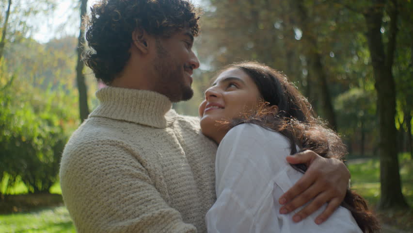 Happy married couple in love african american man indian woman husband wife hugging embrace hug cuddling in park outdoors romantic date in nature loving affection family relationship enjoying together