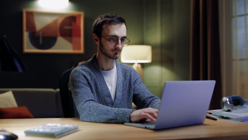 Confident businessman working on laptop computer at home office. Male professional typing on laptop keyboard at workplace. Portrait of positive business man looking at laptop screen indoors Royalty-Free Stock Footage #3427843929