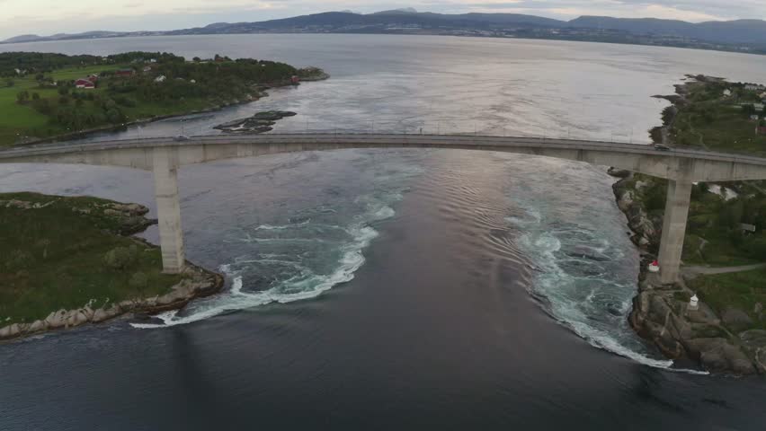 Aerial shot of Saltstraumen Bridge in Norway, showing some of the tidal currents and on the horizon you see the city of Bodo. Royalty-Free Stock Footage #3427913953