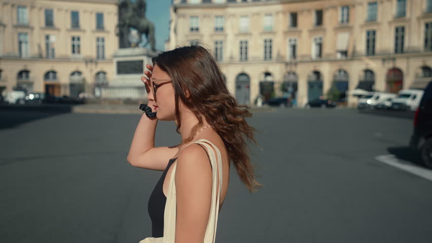 A Fashionable Young Woman Explores the Iconic Streets, Basking in the Warm Sunlight