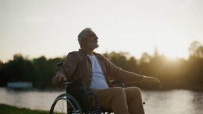 Senior man in wheelchair enjoys freedom. Male with special need spreading arms on sides smiling breathing fresh air walking in the city park. Living with physical disability in old age concept. - Powered by Shutterstock - Get 15% off with code: PIKWIZARD15