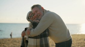Happy smiling senior man hugging woman on sea beach at sunset in evening. Elderly couple family on important date cuddling embracing talking. Lifelong relationships and happy marriage concept. - Powered by Shutterstock - Get 15% off with code: PIKWIZARD15
