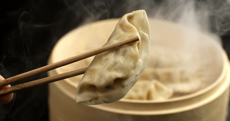 Super slow motion of organic soy sauce dripping on steamed homemade asian traditional recipe fresh pasta gyoza stuffed with meat kept with bamboo chopsticks in japanese chinese restaurant at 1000 fps. Royalty-Free Stock Footage #3428004743