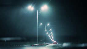 Driving a car at night in the fog along a highway illuminated by lanterns. Desolate night road brightly lit by a sequence of street lamps, with space traffic - Powered by Shutterstock - Get 15% off with code: PIKWIZARD15
