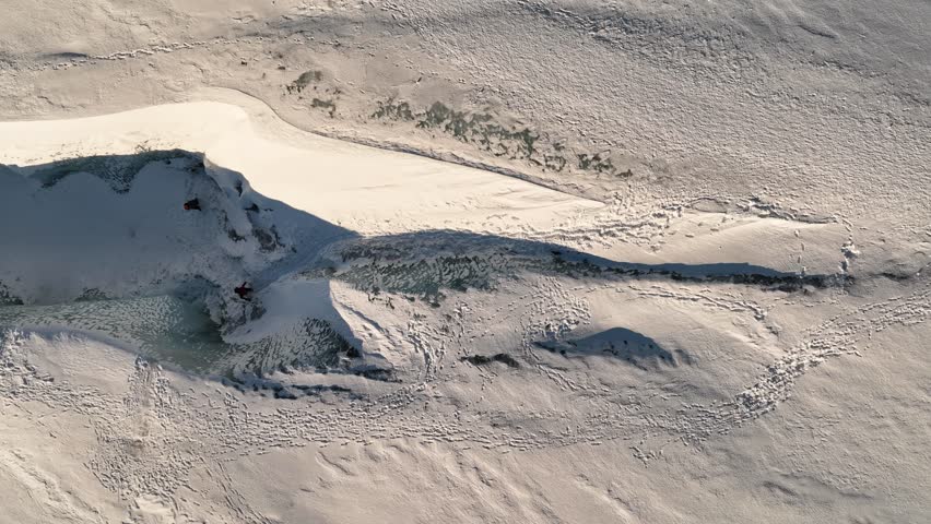 Aerial top view over people hiking on Sólheimajökull glacier, in Iceland, at dusk