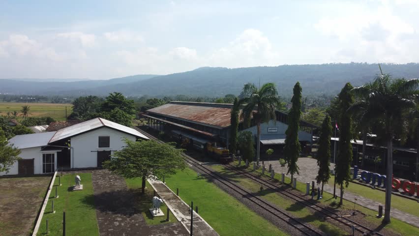 the train is stopping at the old station. the train is in the railway museum located in ambarawa, indonesia. the museum is called museum kereta api ambarawa