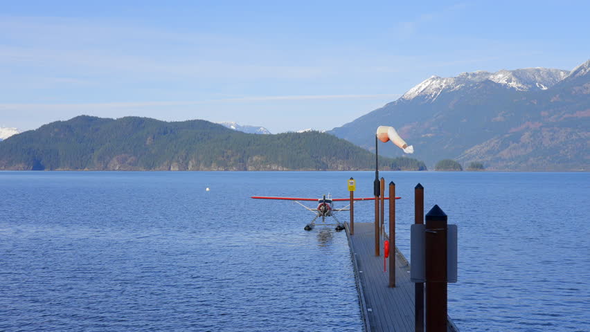 Establishing shot of Mountain lake with blue sky and snow mountains in Vancouver, Canada, North America. Day time on Jan 2024. Still camera view. ProRes 422 HQ.