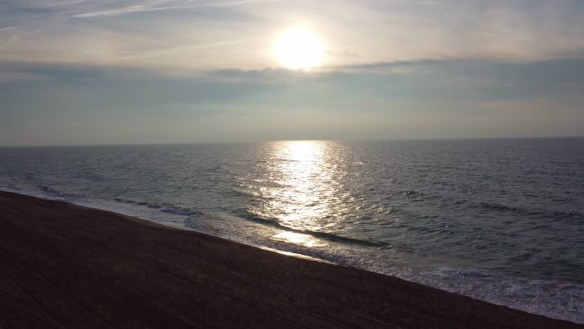 Coastline at sunrise with gentle waves and a tranquil vibe at Castelldefels Beach (Barcelona)