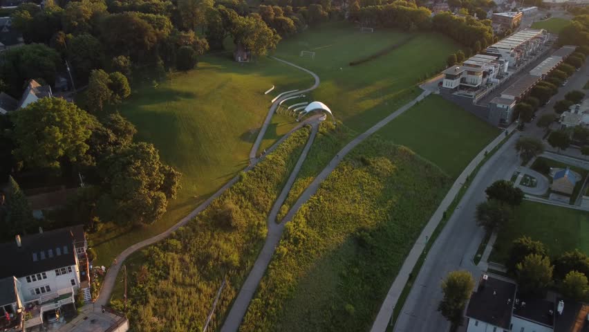 Drone push in towards Riverwest 24 cyclists on Kadish Park in Milwaukee during sunrise golden hour 4k
