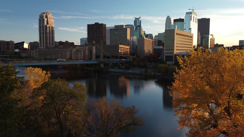Drone boom rise over downtown Minneapolis from Nicollet Island during Fall Golden Hour 4k