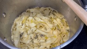 Boiling pappardelle pasta in scampi sauce.