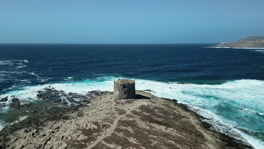 Sea current and Waves crashing at La Pelosa Tower Sardinia, Aerial