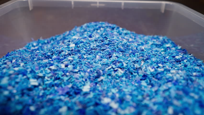 Close-up of shredded plastic caps stored in a special container waste recycling station