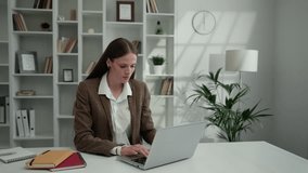 Young Charming Business Lady Working at Home Using Laptop. Serious Girl Works Remotely Sitting in Home Office. People and Technology Concept - Powered by Shutterstock - Get 15% off with code: PIKWIZARD15
