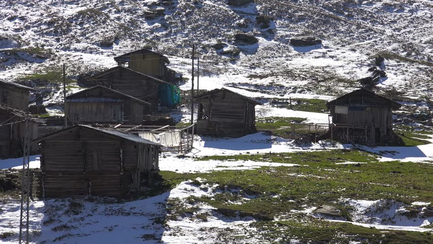 The first snow of the season fell on the wooden village houses in the plateau.