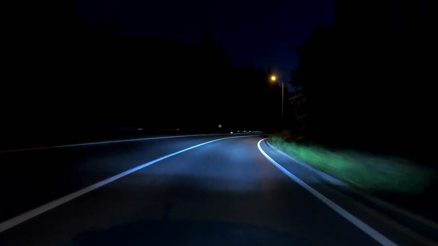 driving a car on countryside road at night with adaptive matrix headlights