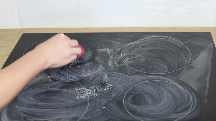 Housewife cleaning and polish electric cooker. Black shiny surface of kitchen top, hands, detergent.