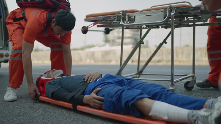 Professional team rescue helping crash victim after car accident on hightway road before being taken to the hospital. EMS Paramedic. First aid procedure. Emergency Medical First aid