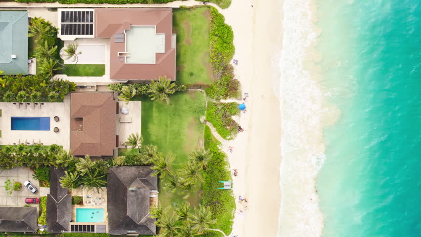 Expensive oceanfront beach villa with blue pool in Kailua town. Luxury lifestyle Oahu USA 4K. Overhead properties on scenic Hawaii Island. Top down real estate business for sale offer copy background