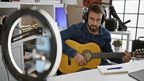 Check out this passionate young hispanic man nailing classical guitar melody in music studio, recording video with smartphone!