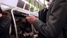 A Japanese businessman in the subway, engrossed in his smartphone, seamlessly blends business with the urban rhythm of the city. - Powered by Shutterstock - Get 15% off with code: PIKWIZARD15