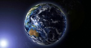 Animation of the moving earth in space, the globe illuminated by the sun's rays. Australia and East Asia in the frame. 3D rendering 4K video. Image elements courtesy of NASA
