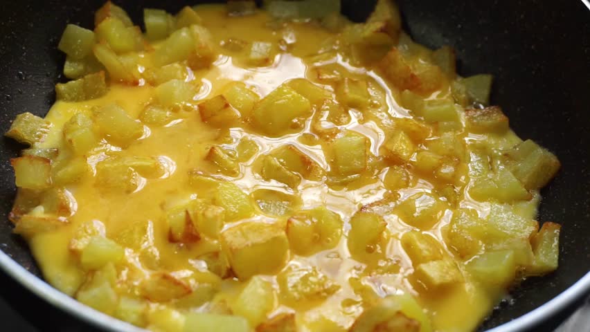 Close up of potato omelette cooking in a pan