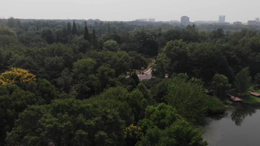 4k cinematic drone video in China. Qian lake in Nanjing. Panoramic view of lake in asia with small touristic boat. Modern asian city skyline in background. Green park in asia China.