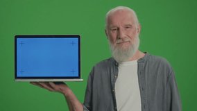 Green Screen.Portrait of an Old Man with a Laptop with Blue Screen Shows Thumb Up. Security and Privacy Concerns for Senior Tech Users. Emerging Technologies for Seniors.