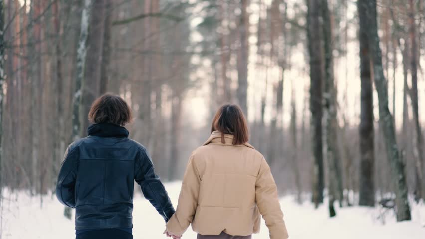 happy couple in love in leather jackets in winter in a snowy forest on a date.
​