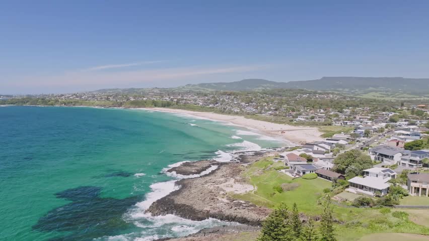 Stunning aerial drone flight over Minnamurra Lookout with Jones Beach and Kiama Downs, a coastal country town 120 kilometres south of Sydney, New South Wales, Australia, in the background.  Royalty-Free Stock Footage #3429122751