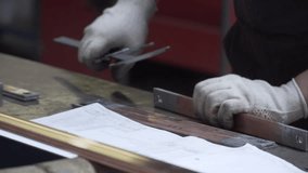Worker measuring an aluminum metal piece with calliper.