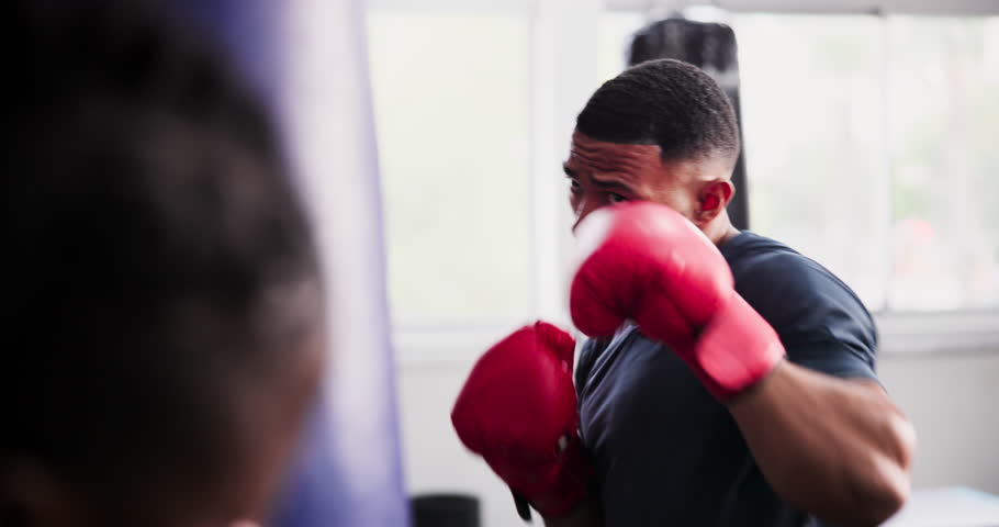 Man, boxer and punching bag for fitness, workout and coach with gym training in MMA, fight and support. Strong people with fist, power or boxing challenge and personal trainer helping with exercise