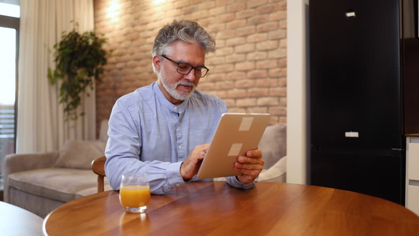 Man surfing the net on a tablet Royalty-Free Stock Footage #3429285945
