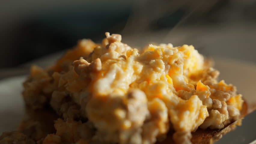 A culinary masterpiece unfolds under the dramatic morning light as scrambled eggs on a plate emit warmth. The play shadows and highlights creates a visual textures and flavors. High quality 4k footage Royalty-Free Stock Footage #3429320099