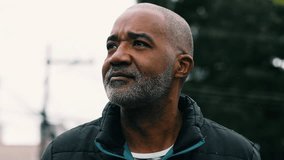 One thoughtful rough looking middle aged South American Black man walking in urban street, close-up face of An African descent person in 50s with pensive meditative gaze - Powered by Shutterstock - Get 15% off with code: PIKWIZARD15