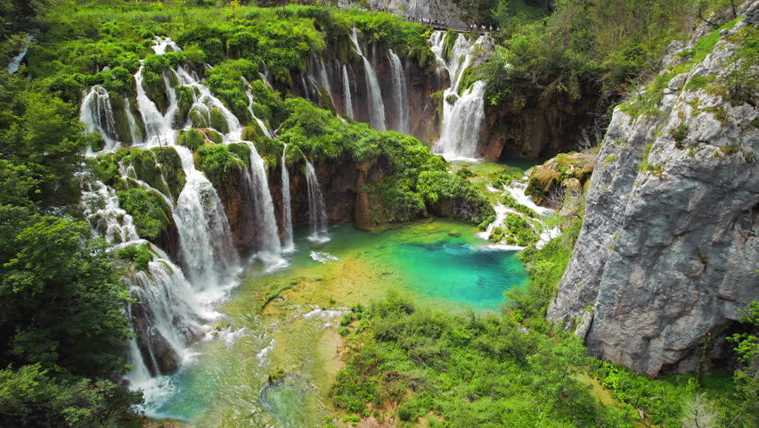 Summer forest and mountain landscape with streams of water and waterfalls. Cascades flow among lush greenery.