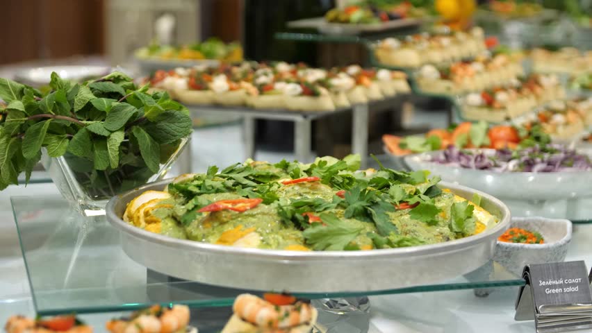 Close-up of a buffet table with canapes, vegetables and herbs in a restaurant. Close-up of canapes, vegetables and herbs on a banquet table. Royalty-Free Stock Footage #3429566677