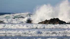 Hign definition 1080p video of crashing waves over rocks and against blue sky along Pacific Ocean in Cannon Beach Oregon 1920x1080