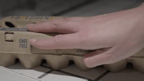 This video shows a close up view of a hand opening an empty egg carton with nothing inside.