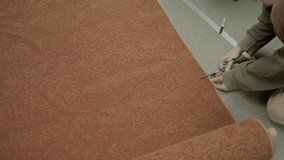 This video shows a top view of a tailor seamstress cutting upholstery fabric by hand.