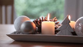 Festive and elegant advent table decoration in christmas season, full HD 1080 video, camera panning across the decoration with lit candles