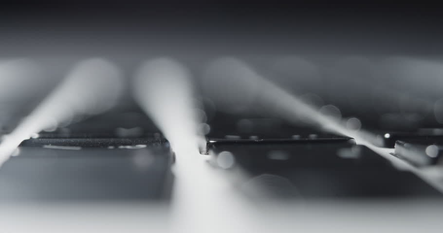 Extreme Close-up of Finger Pressing Keys on Laptop Keyboard